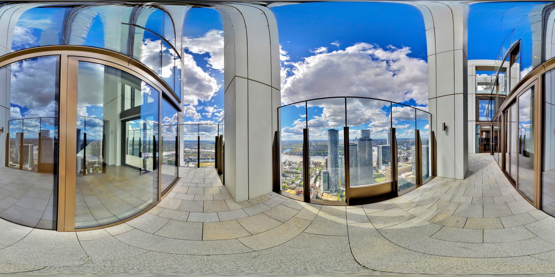 Wraparound terrace with curved stone arches and the Canary Wharf towers beyond under open sky